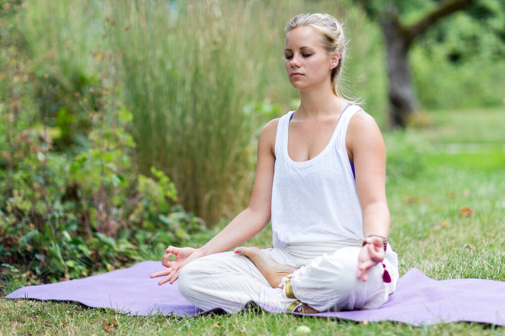 Meditation im Lotussitz im Garten